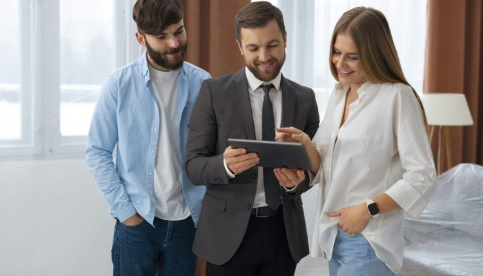 agente-imobiliario-masculino-fazendo-negocios-e-mostrando-casa-para-um-possivel-casal-comprador